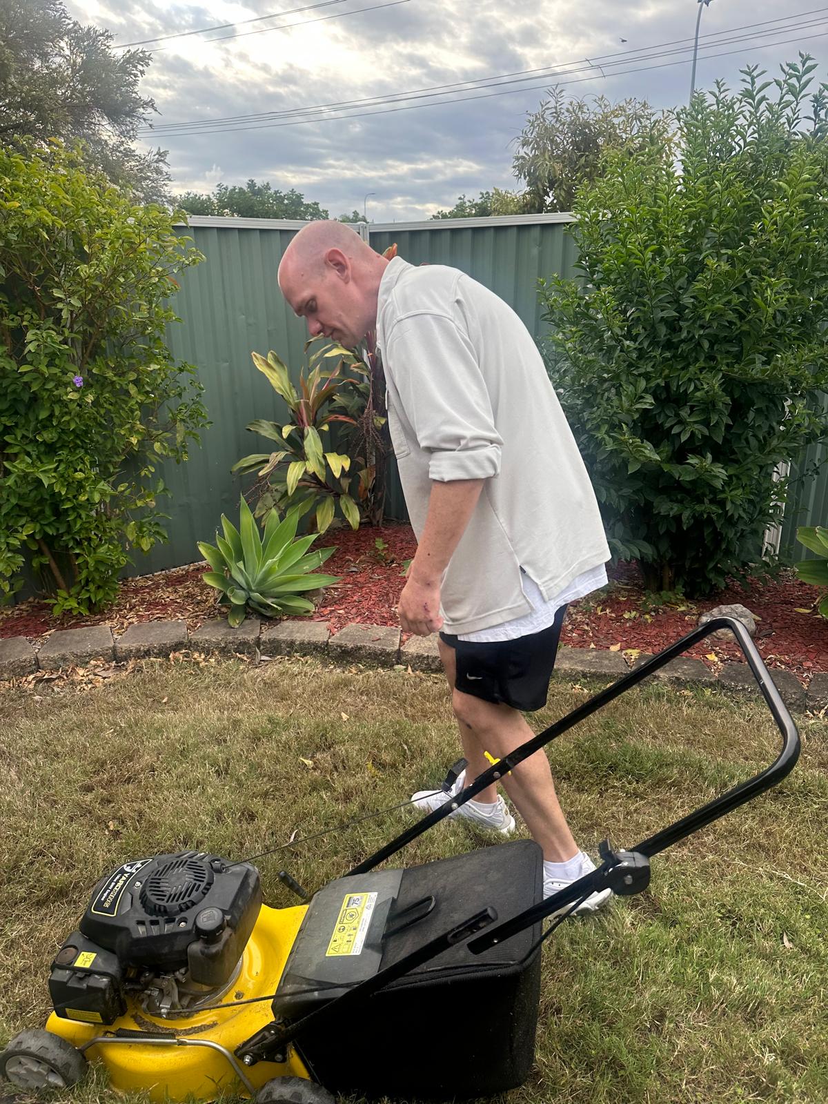 Participant mowing the lawn building daily living skills